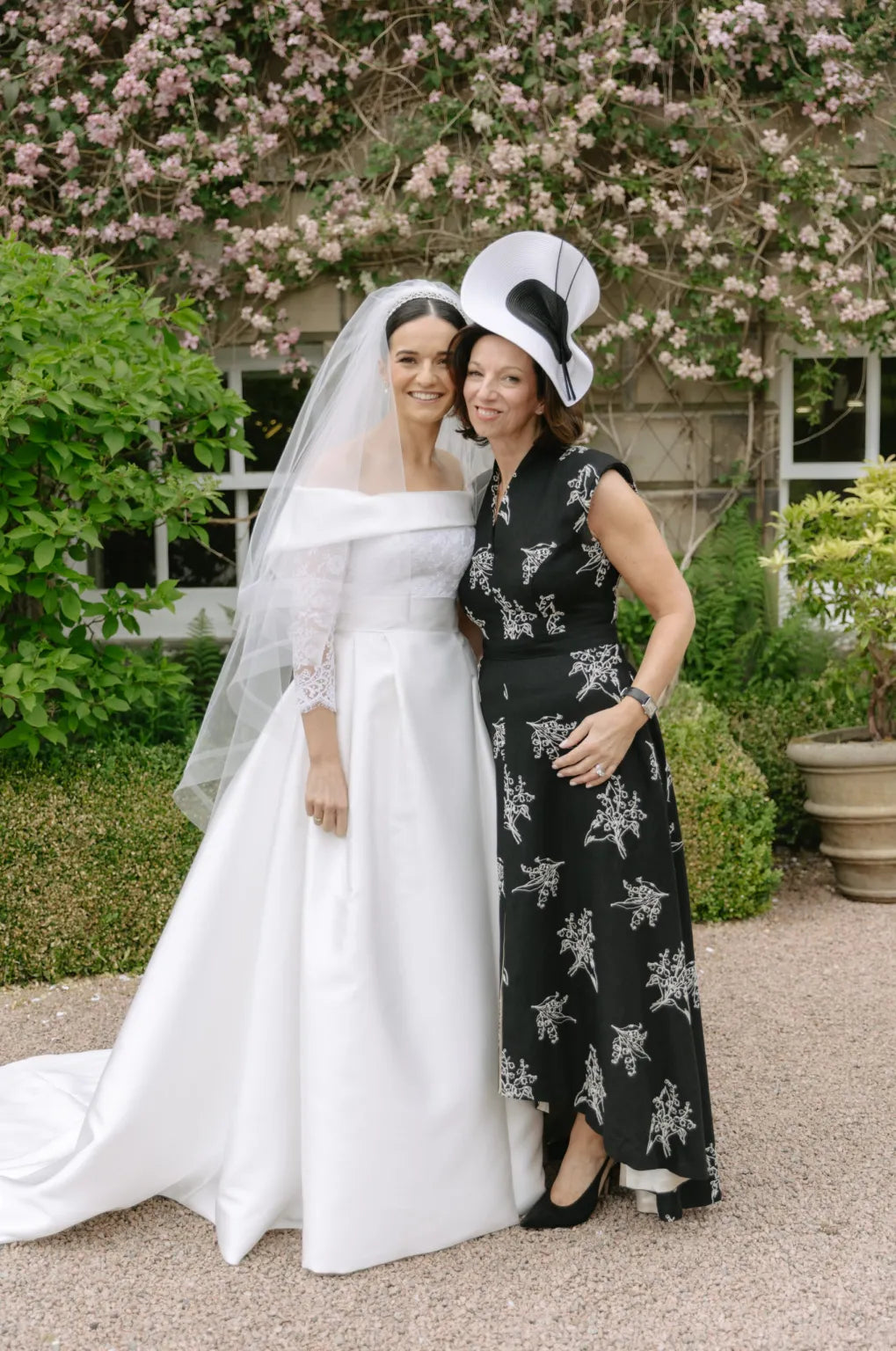 A mother of the bride wearing a Joyce Young teal cape outfit at a wedding venue